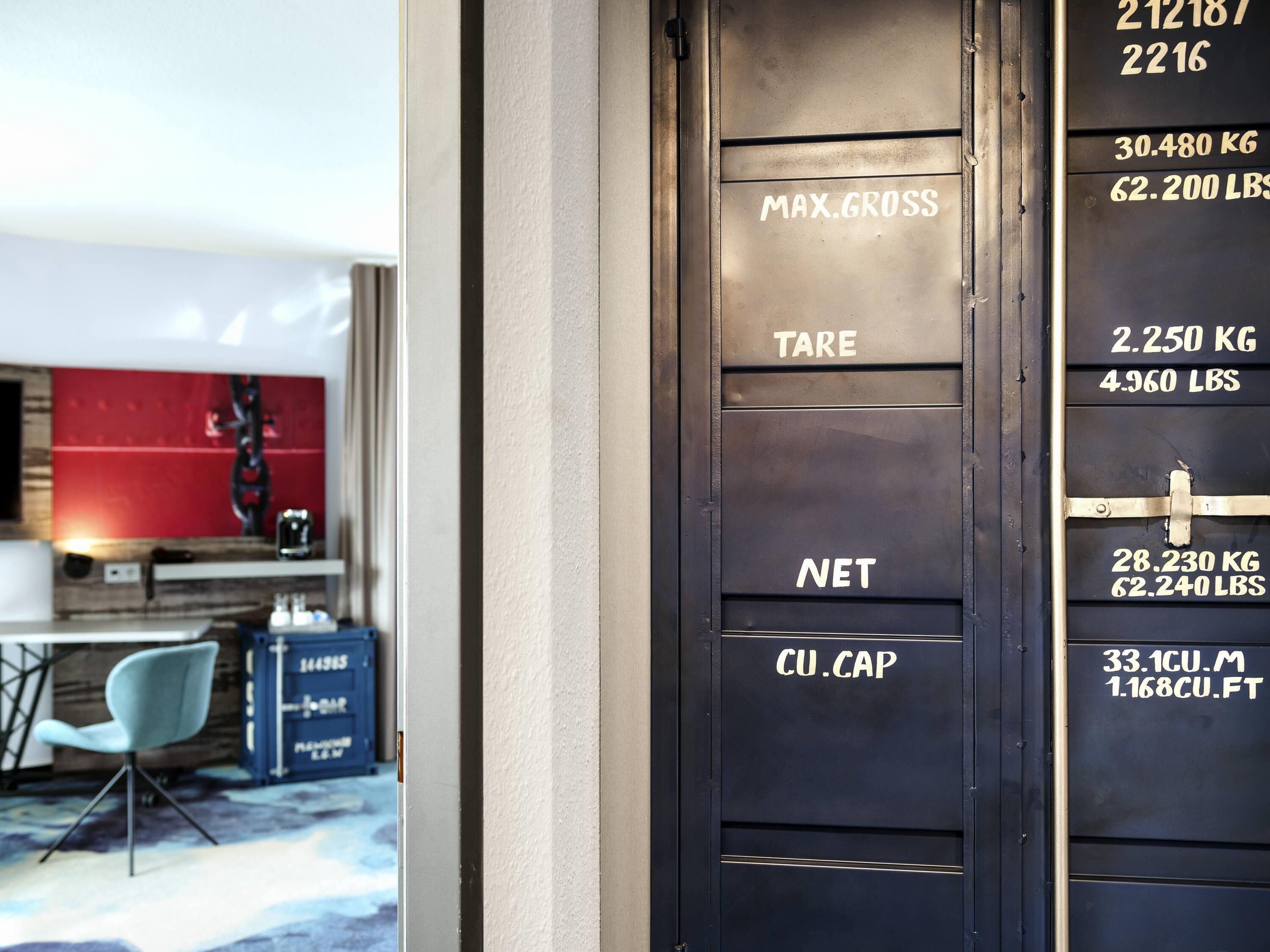 A black metal door with weight capacity labels: MAX.GROSS, TARE, NET, CU.CAP.