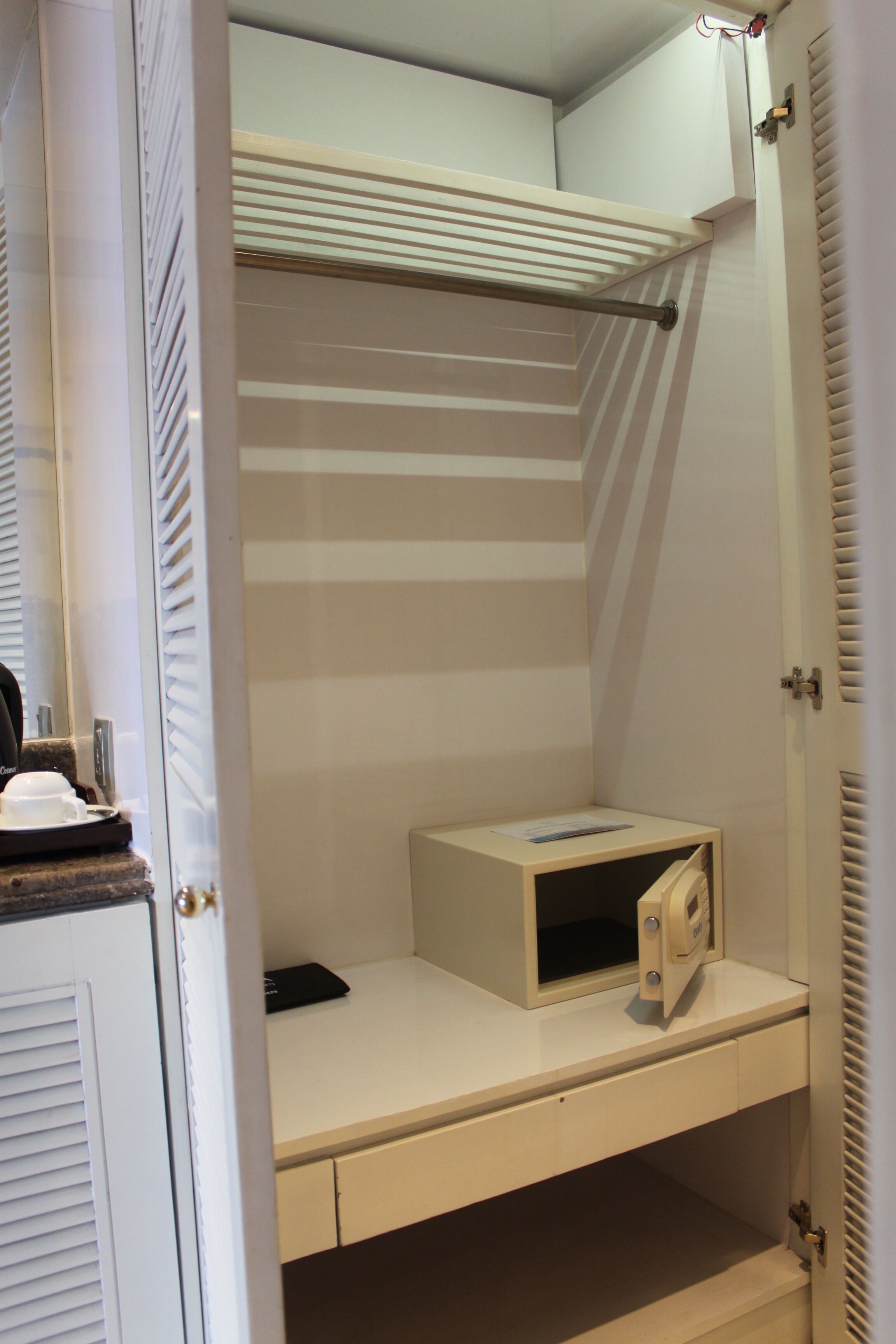 A compact room with a bunk bed, a small desk with a chair, and a shelf.