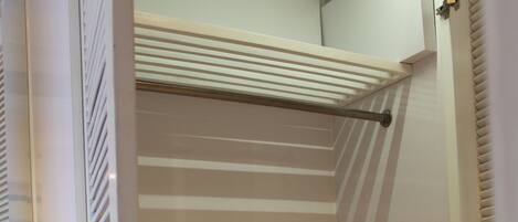 Una habitación pequeña con una litera, un escritorio y una silla, además de una estantería.