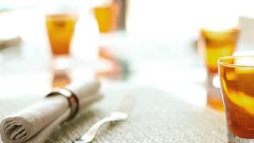 Une table avec une serviette pliée, une fourchette et un verre contenant une boisson.