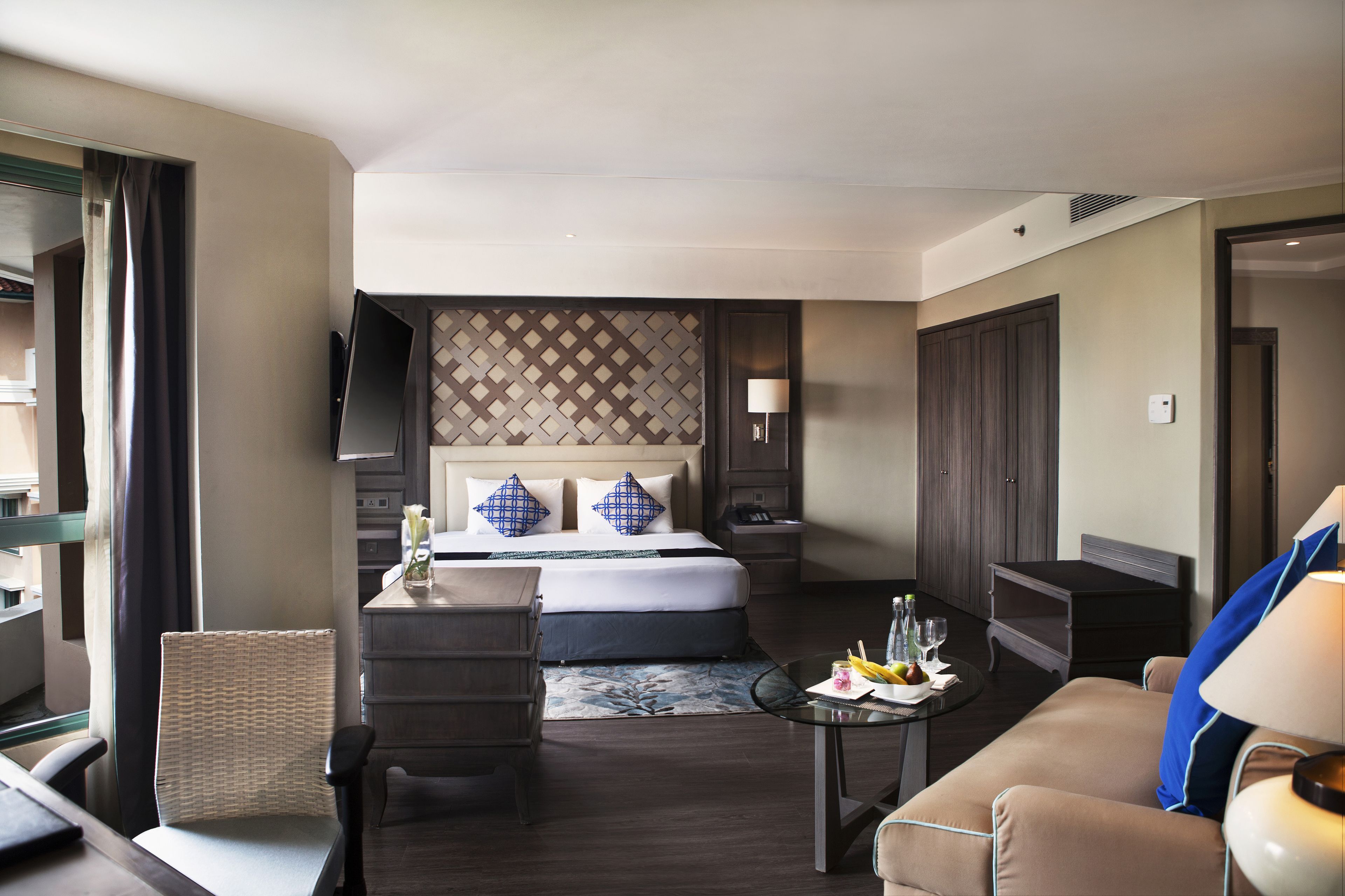 Een hotelkamer met een bed, een bureau, een stoel, een bank en een televisie.