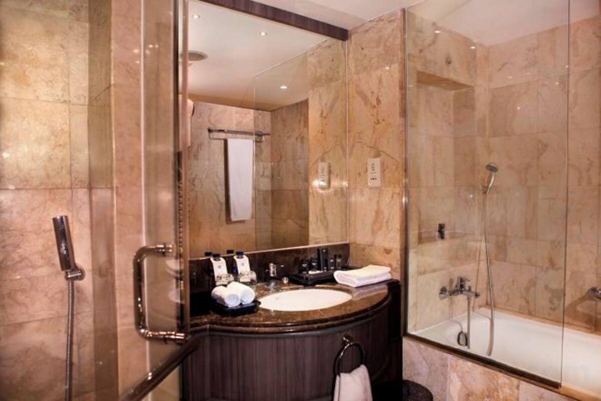 Un baño con ducha de vidrio, lavamanos y bañera.