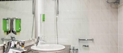 A bathroom with two sinks, a shower, and a bathtub.