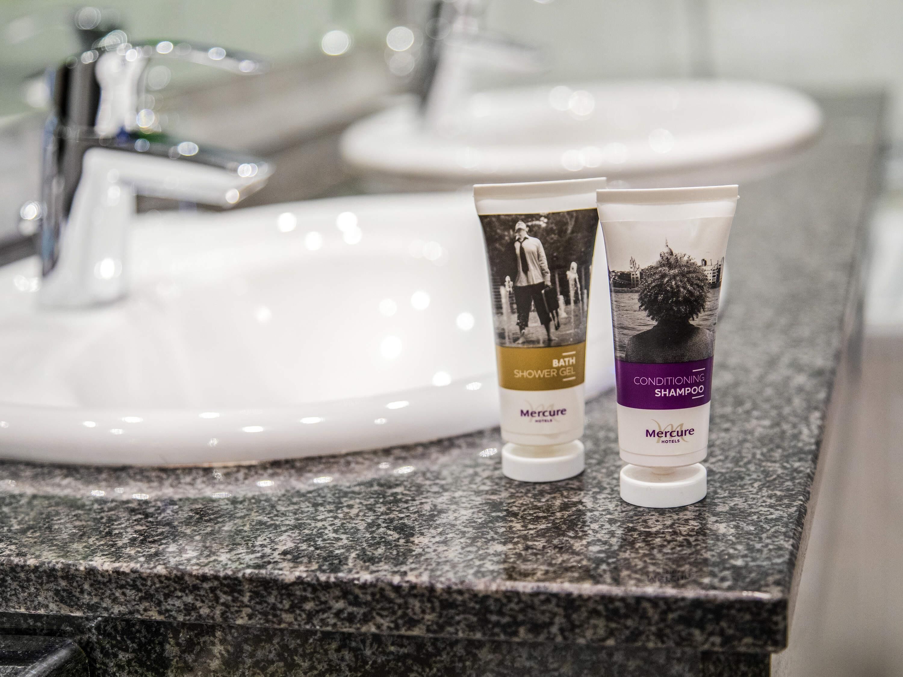 Zwei Flaschen Toilettenartikel vom Hotel Mercure auf einer Granitplatte.