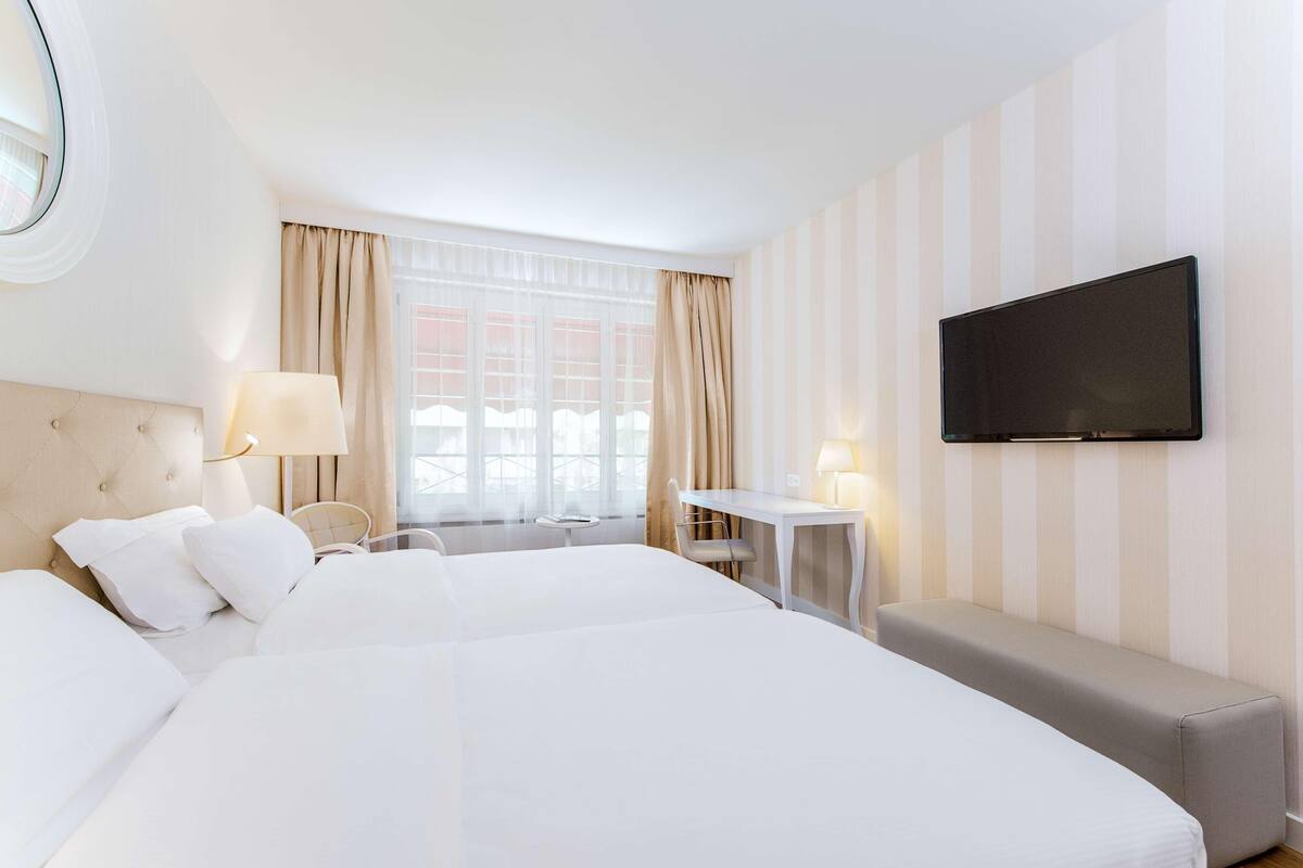 Ropa de cama hipoalergénica y caja de seguridad en la habitación
