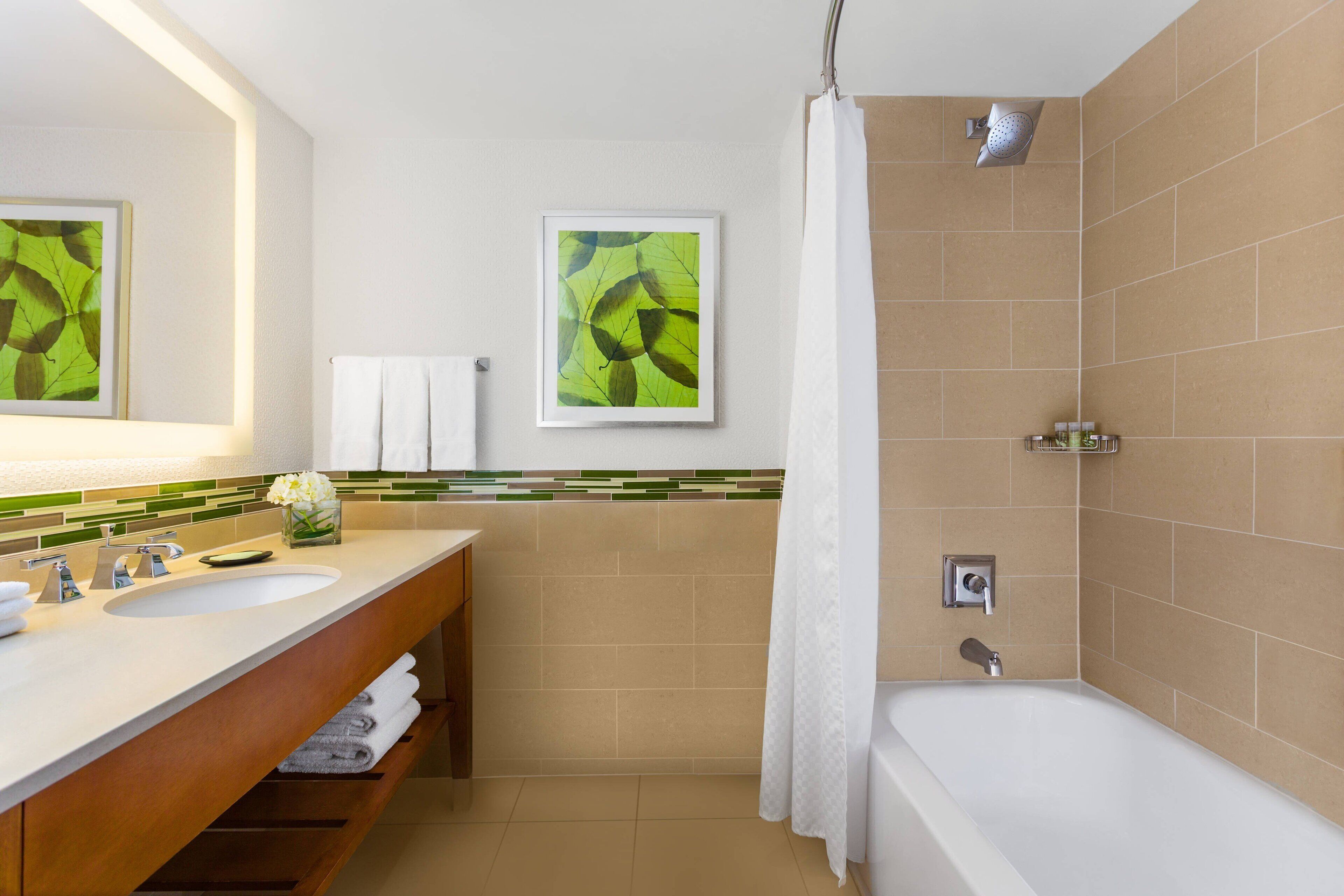 Ein Badezimmer mit Waschbecken, Spiegel und Dusche.