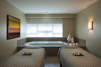 A modern hotel room with a grey sofa, armchairs, a dining area, and large windows offering a city view. at Hyatt Regency Orlando