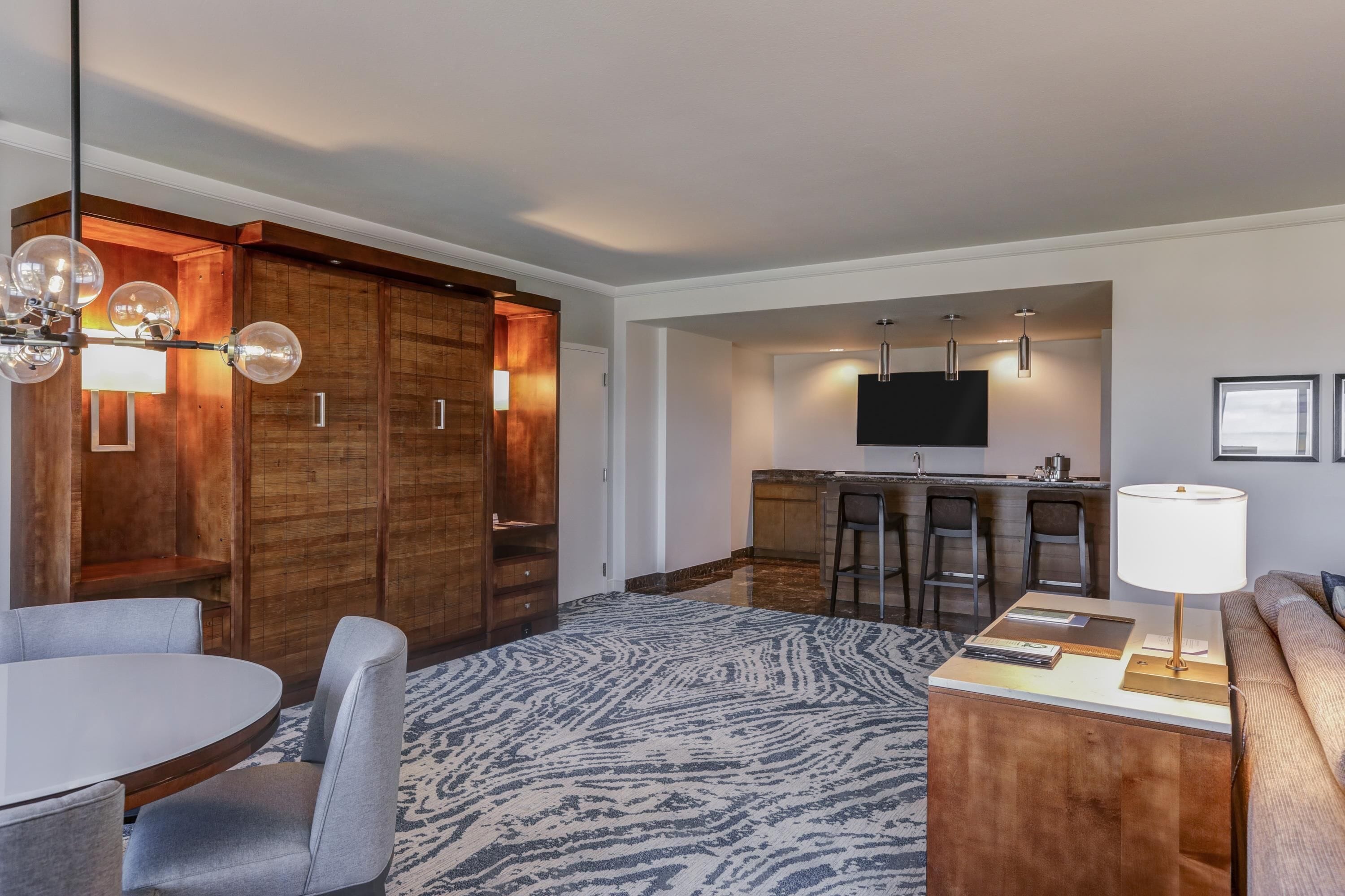 Een moderne hotelkamer met een zithoek, keuken en eethoek.
