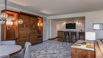 Een moderne hotelkamer met een zithoek, keuken en eethoek.