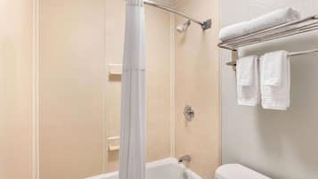 Un baño con una bañera, una cortina de ducha y un perchero con dos toallas.