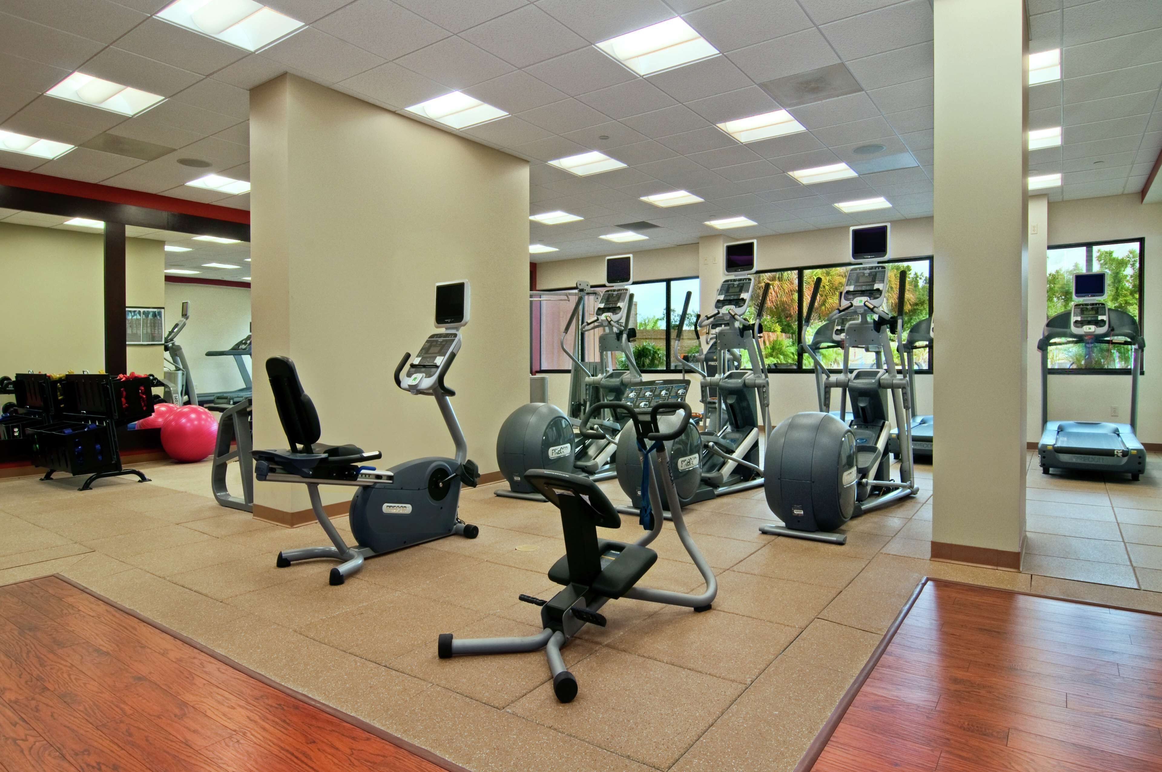 Un gimnasio con varias máquinas de ejercicio, una cinta de correr y una bicicleta estática.