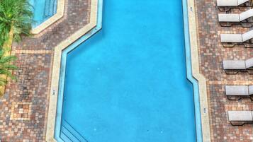 Alberca al aire libre, sombrillas en la alberca y camastros