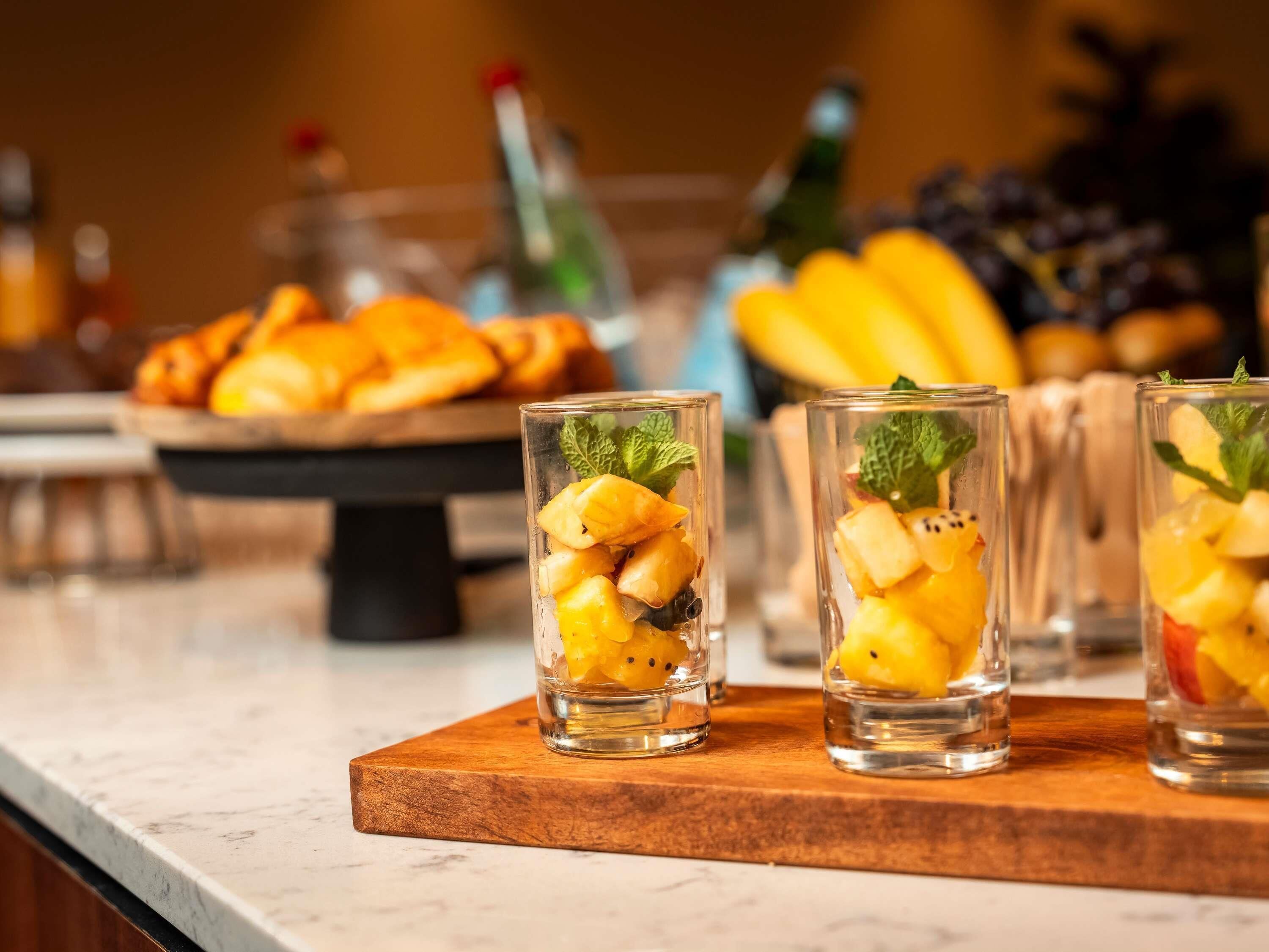 Three glasses of fruit cocktail on a wooden board.