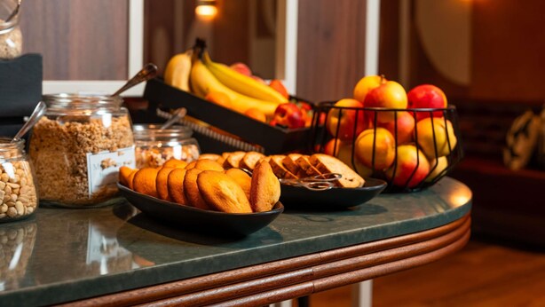 A breakfast buffet with various fruits, bread, and cereal.