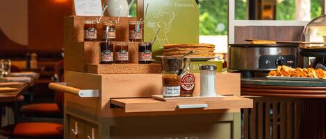 A buffet setup with various food items and condiments at Bons & Vivants Mercure Hotels.