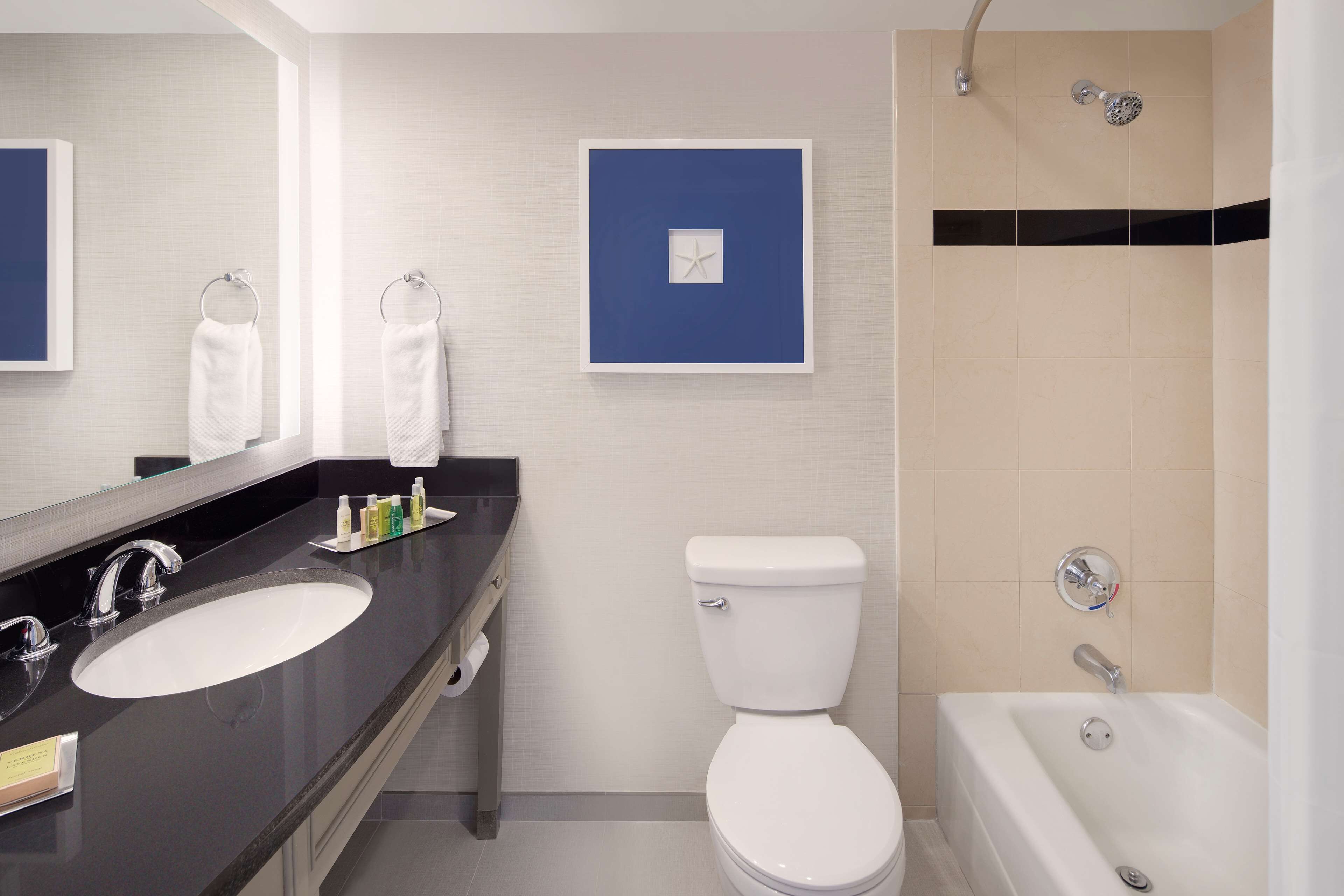Un baño moderno con lavamanos, inodoro y bañera.