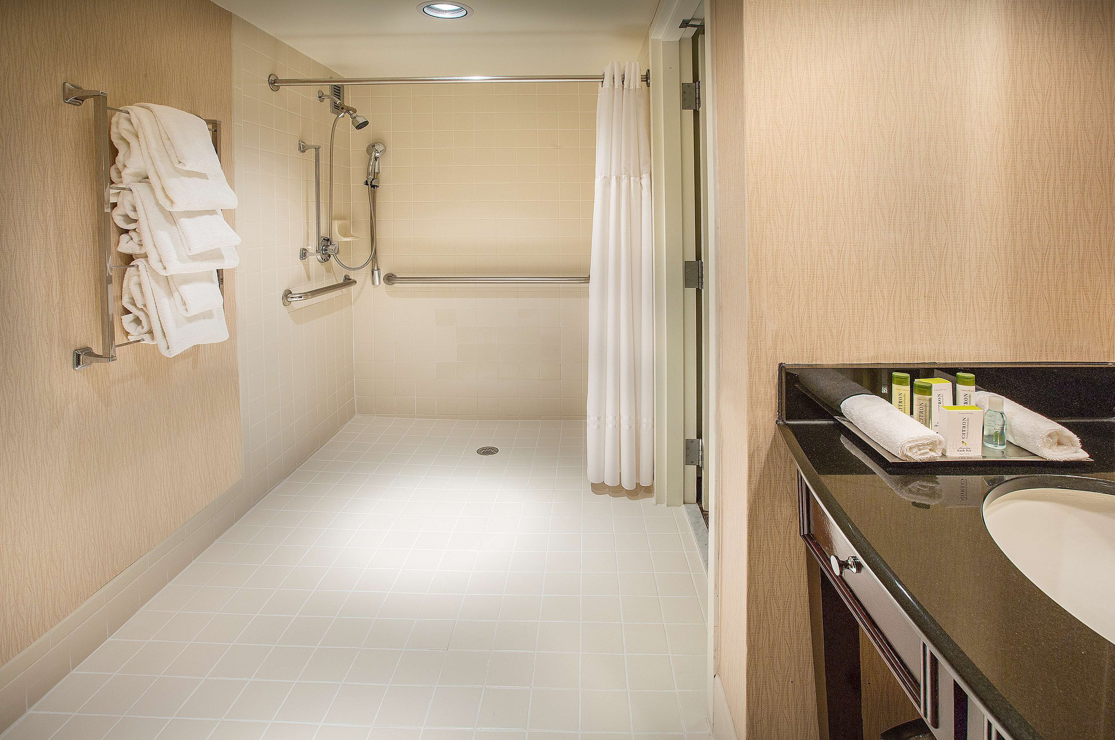 Ein modernes Badezimmer mit barrierefreier Dusche, Toilette und Waschbecken.