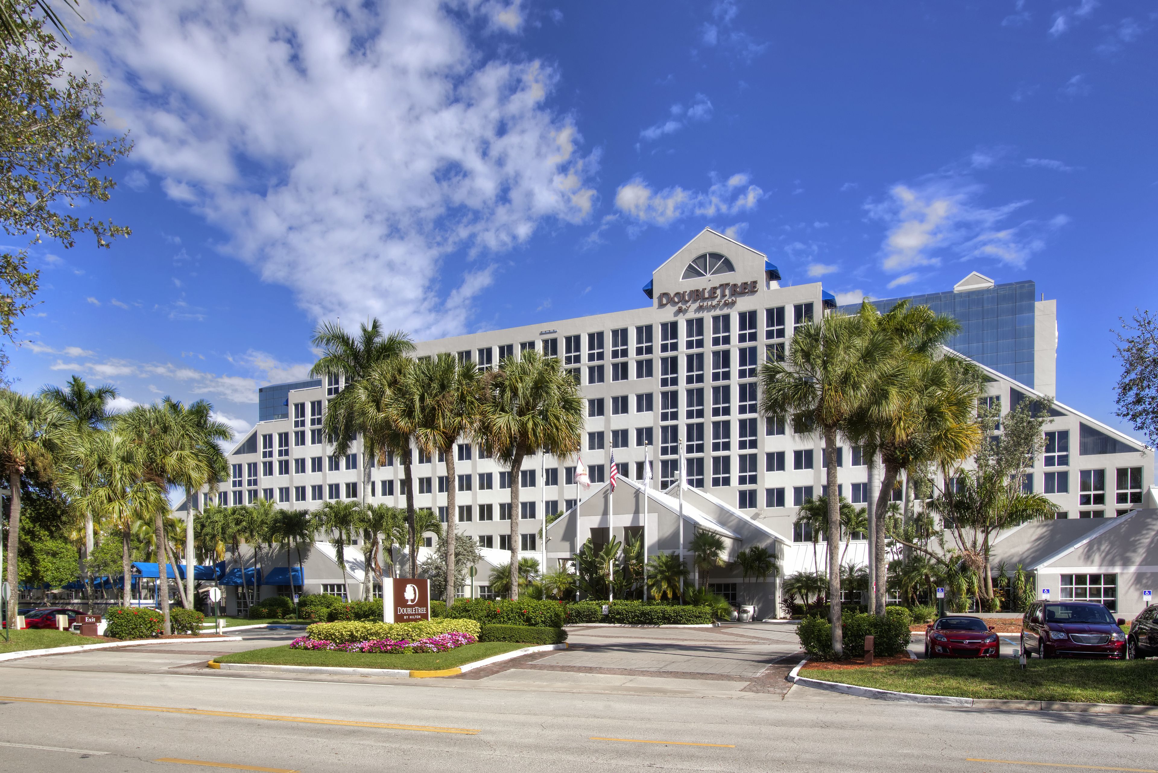 A large hotel with a modern design, featuring a prominent sign and multiple floors.