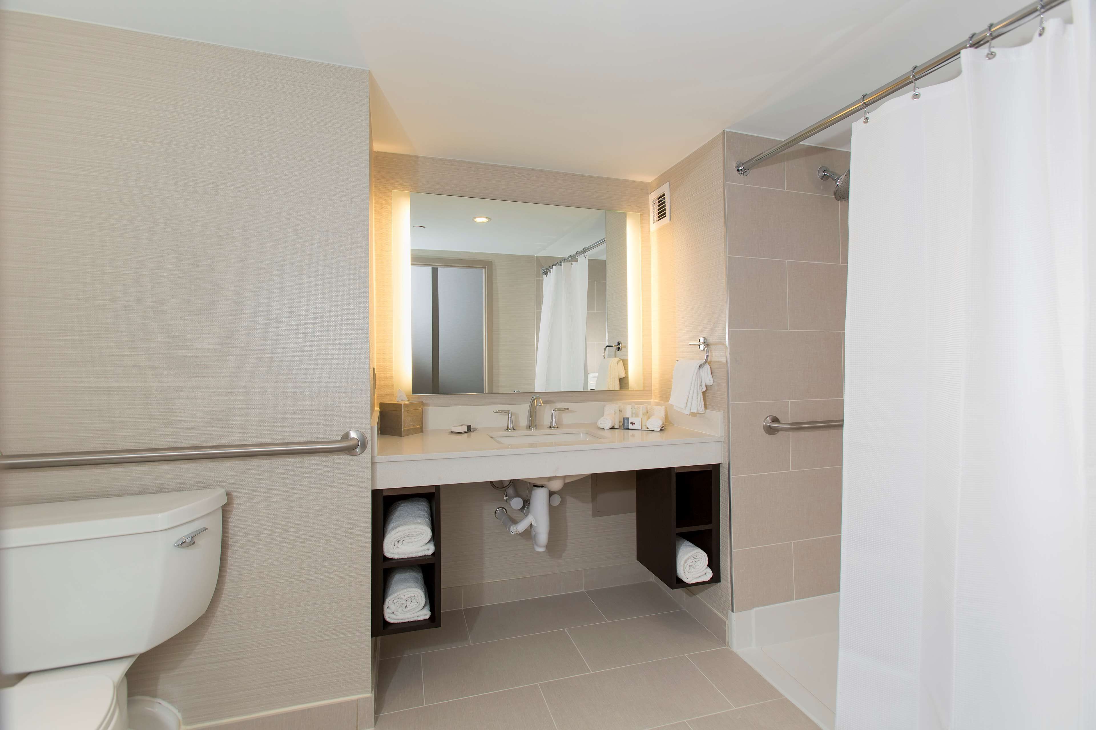 Et moderne badeværelse med toilet, vask og brusebad.