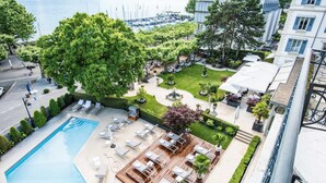 Un espace piscine aménagé sur le toit, avec des chaises longues, une petite piscine et une vue sur le port de plaisance.