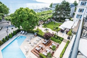 Una piscina al aire libre de temporada, sombrillas