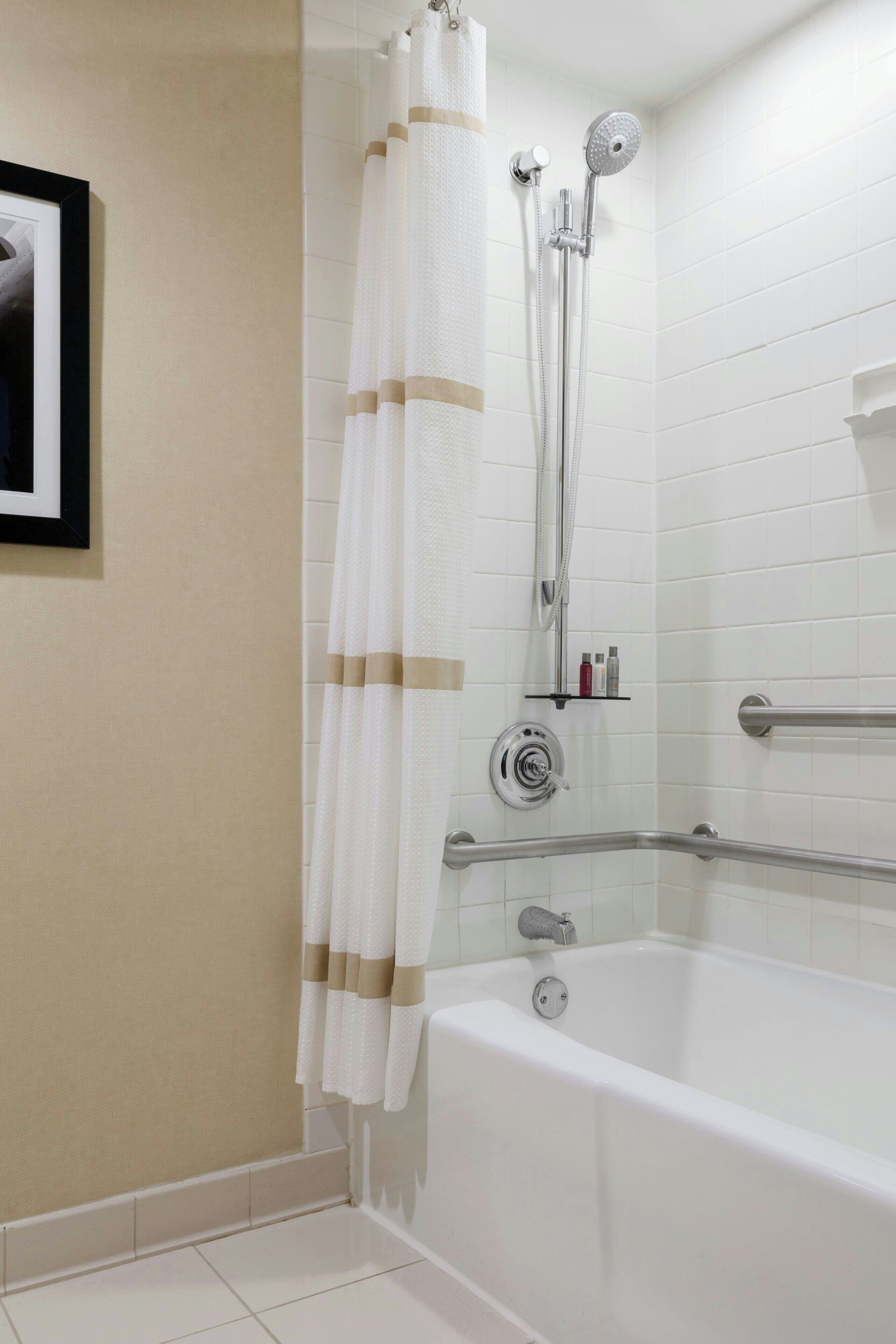 Un baño con bañera, ducha y un perchero para toallas.