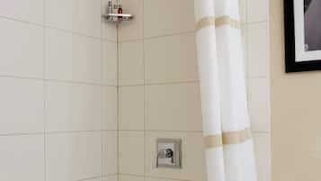 Uma casa de banho com banheira, chuveiro e um quadro emoldurado na parede.