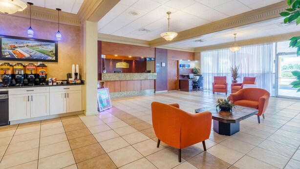 Un vestíbulo de hotel con un mostrador de recepción, zona de estar y una cocina a lo lejos.