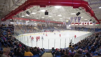 Una pista de hockey sobre hielo cubierta, con espectadores sentados alrededor del borde.