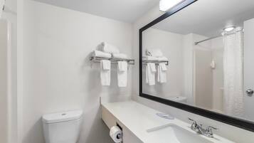 Un baño moderno con un lavamanos blanco, un espejo y un inodoro.