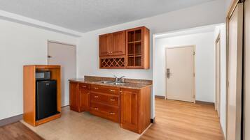 Una cocina funcional con armarios de madera, un microondas integrado y un refrigerador.
