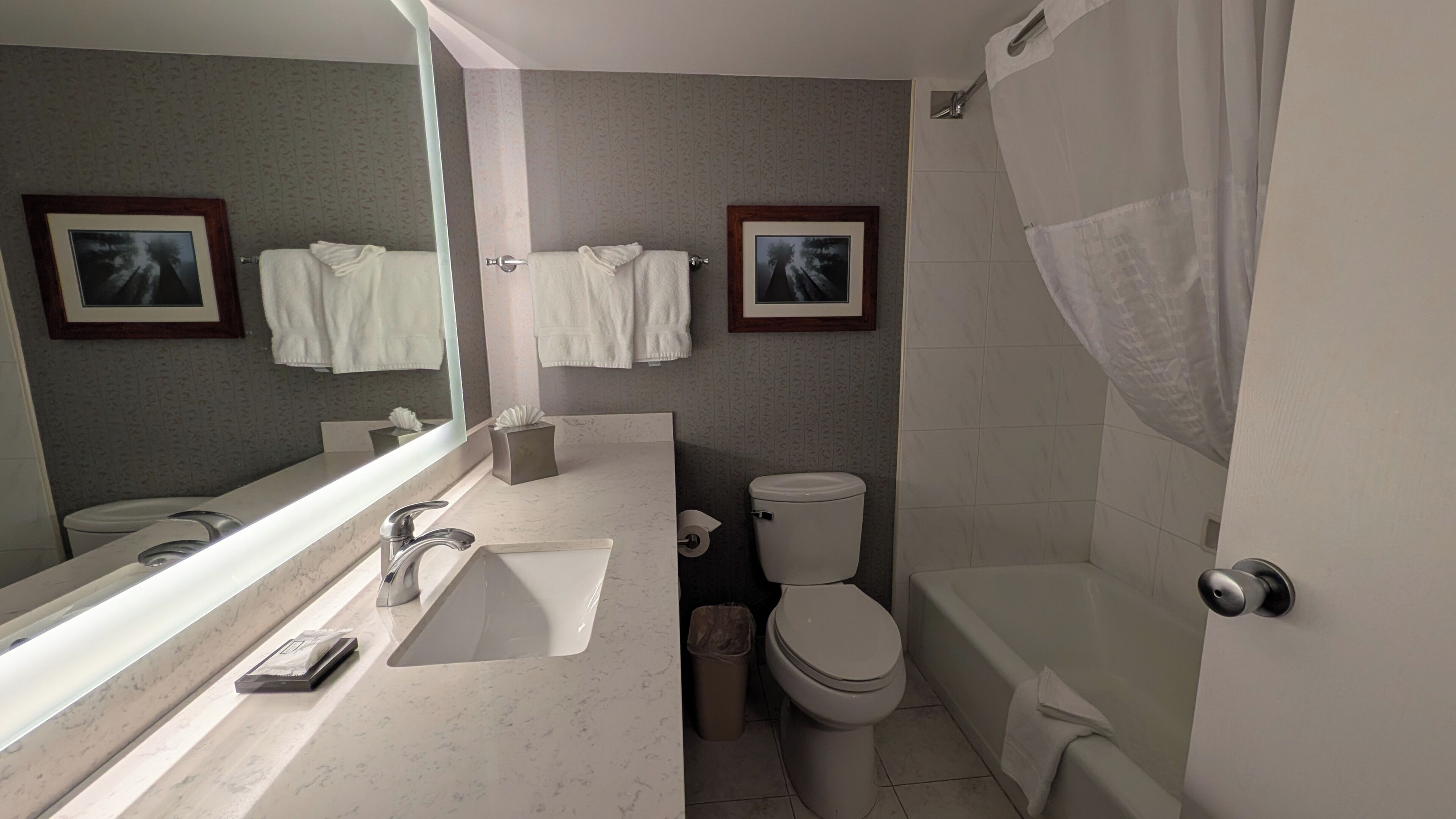 A modern bathroom with a sink, toilet, and bathtub.