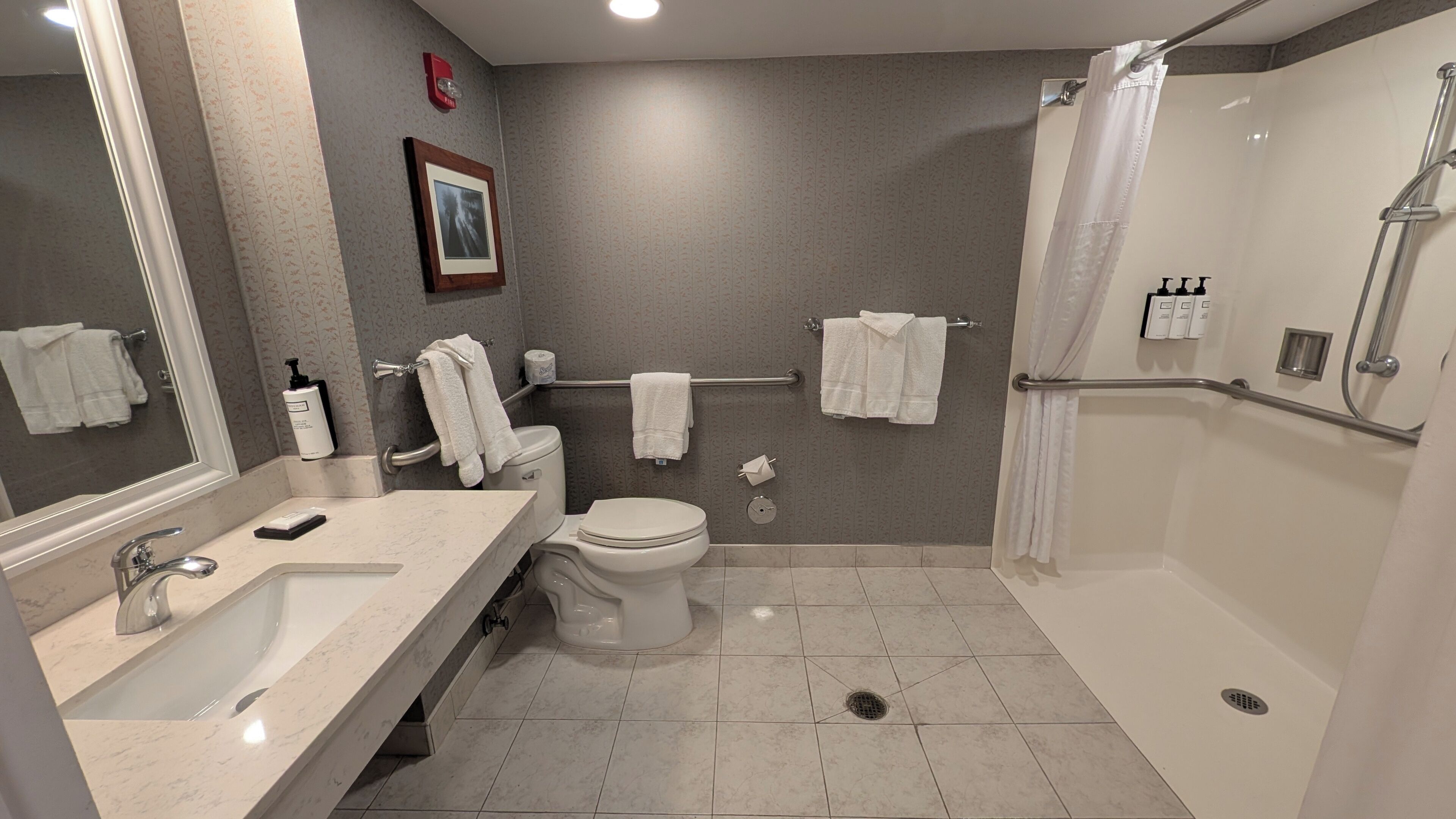 A modern bathroom with a sink, toilet, and shower.