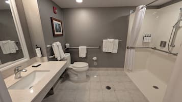 A modern bathroom with a sink, toilet, and shower.