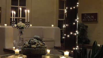 A room with a stone centerpiece, candles, and a sign for 'Elton Orton Rooms'.