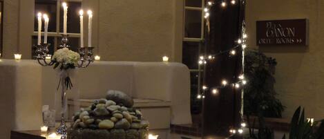 A room with a stone centerpiece, candles, and a sign for 'Elton Orton Rooms'.
