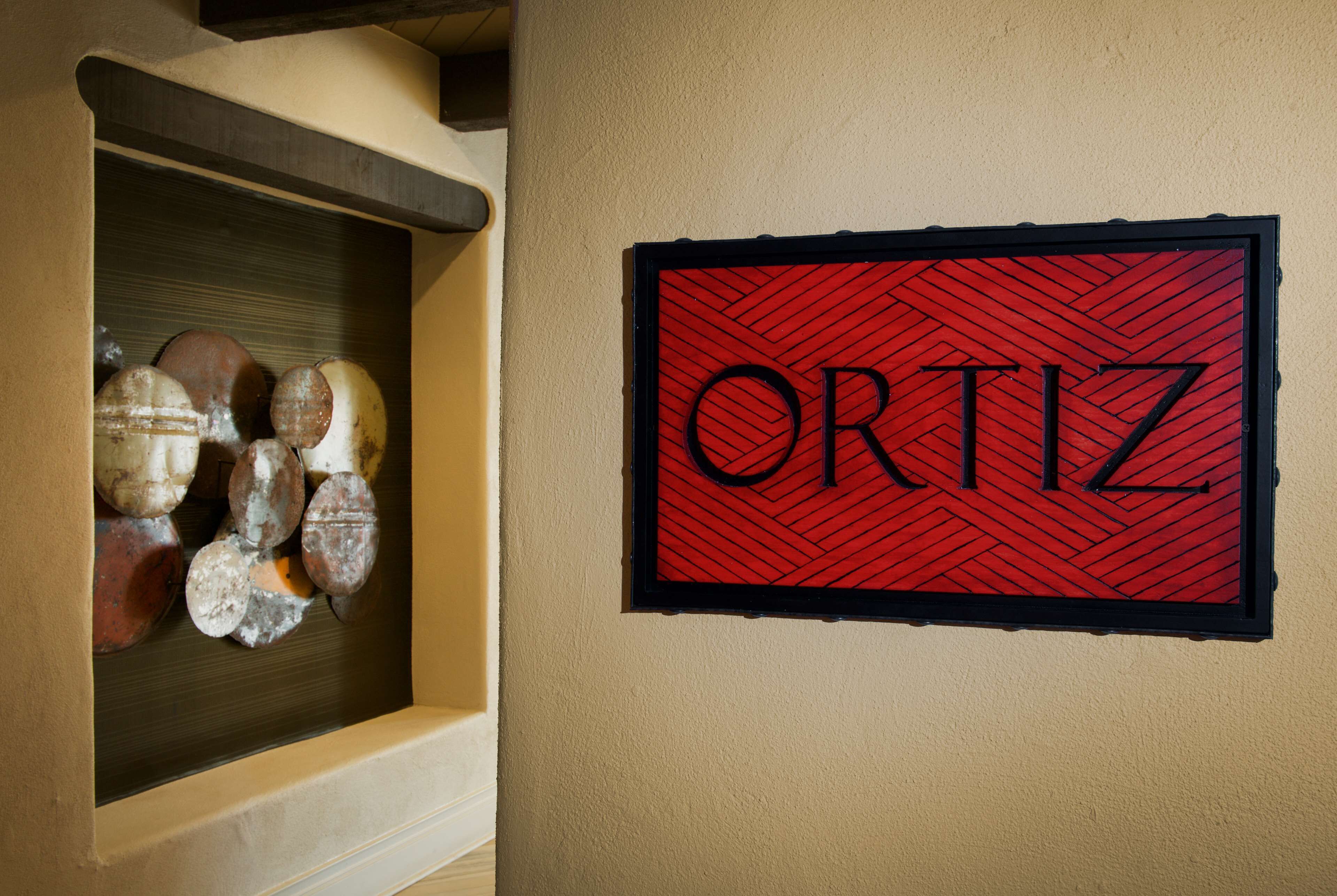 A wall-mounted sign with the name "ORTIZ" in bold letters on a red background with a black border.