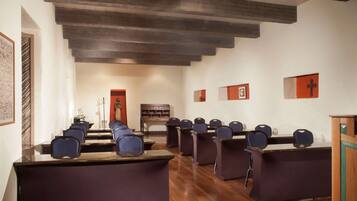 A conference room with a long table, several chairs, and a wooden bench.