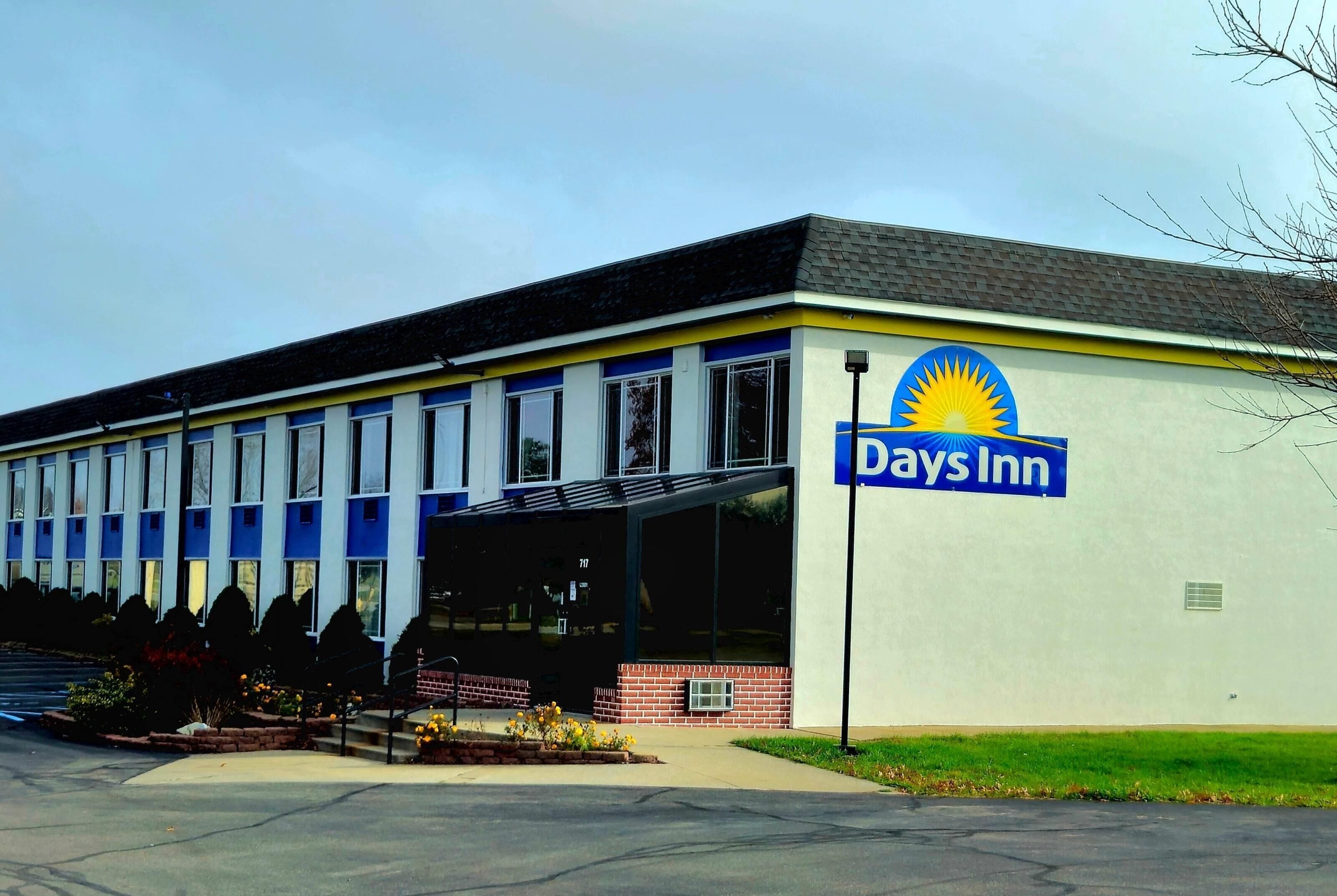 A Days Inn building with a large sign, a covered entrance, and a brick facade.