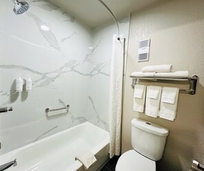 Bathroom features a bathtub, toilet, and shower curtain.