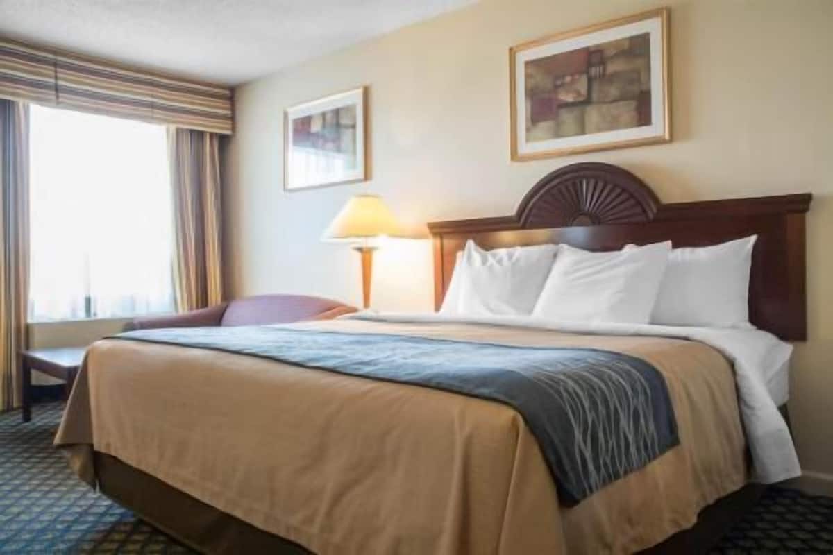 Escritorio, cortinas blackout y tabla de planchar con plancha