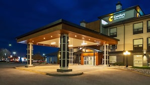 A Comfort Inn & Suites building at night with a covered outdoor area and a well-lit entrance.