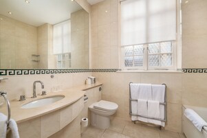Ein modernes Badezimmer mit einem großen Waschbecken, einer Toilette und einer Badewanne.