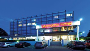 A hotel building with a prominent "Leonardo Hotel" sign. There are multiple cars parked in front, and the entrance is visible with steps leading up to it. - Leonardo Hotel Monchengladbach (Moenchengladbach)