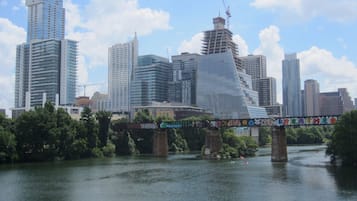 Un río con un puente, rodeado de edificios modernos y un cielo despejado.