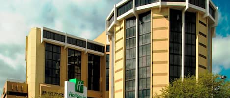 Ein Holiday Inn Hotel mit modernem Design, das einen hohen, zentralen Turm und einen flach gedeckten Flügel zeigt.