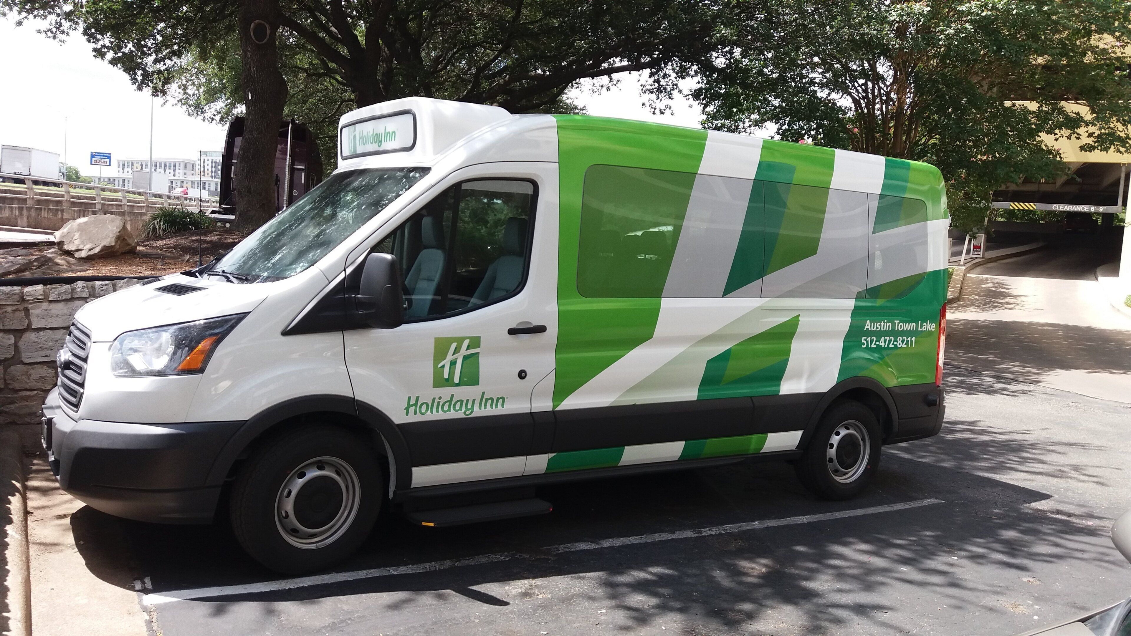 Ein mit dem Branding von Holiday Inn versehener Van steht am Straßenrand.