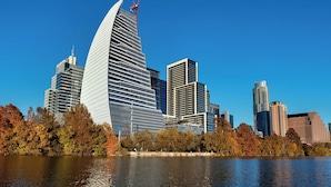 A modern city skyline with a prominent curved building and several other high-rise structures.