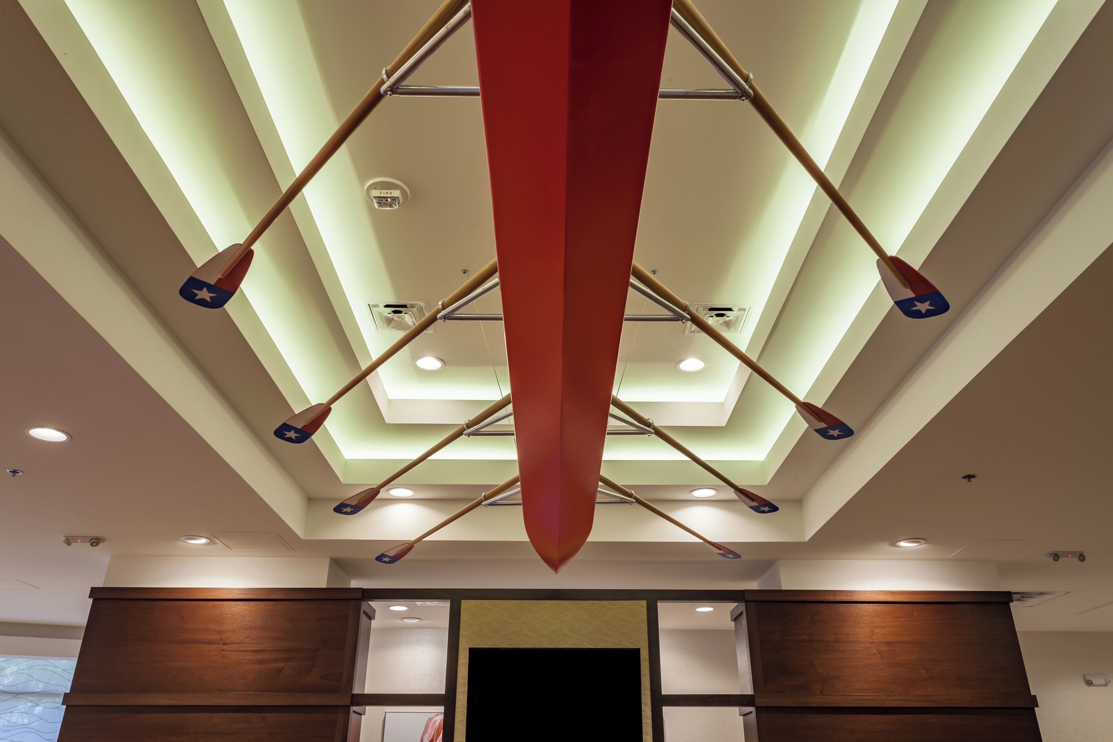 A ceiling with recessed lighting and a central red object.