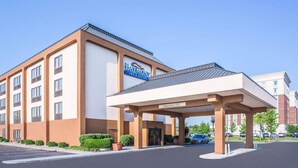 A hotel with a clear entrance, a sign indicating 'Clearance 12' for parking, and a modern architectural design.